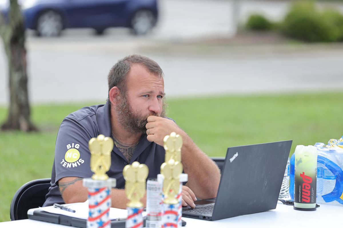 Coach Cole Spivey at the tournament desk during a Big NC event